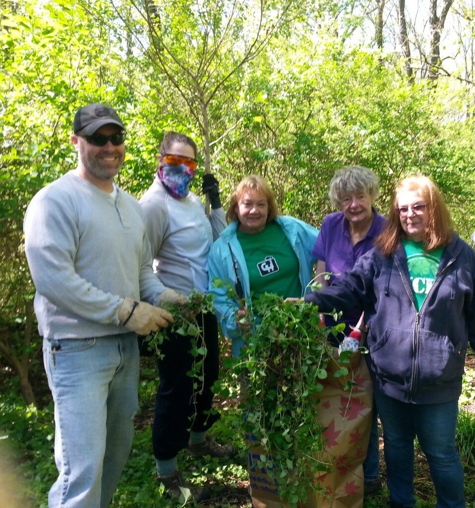 A group photo of Beth Kuser-Olsen and others as they clean up a forest