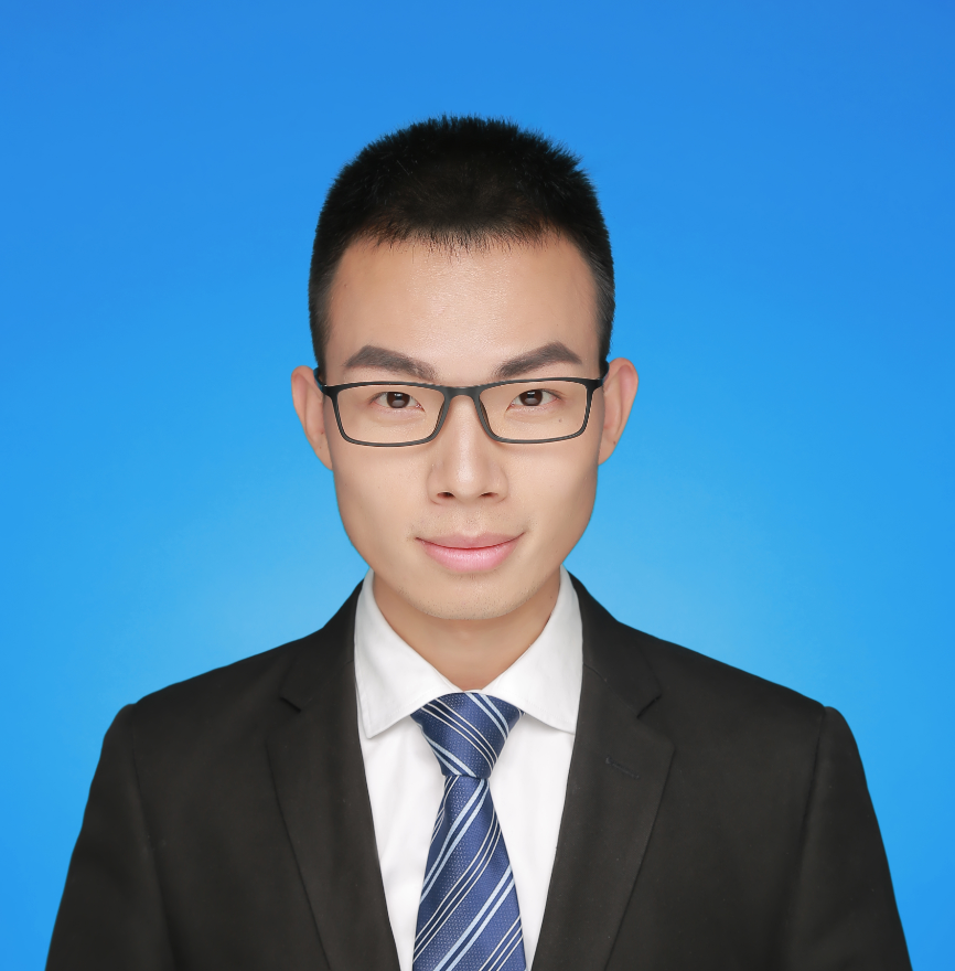 A headshot of Jing, wearing a suit in front of a blue backdrop